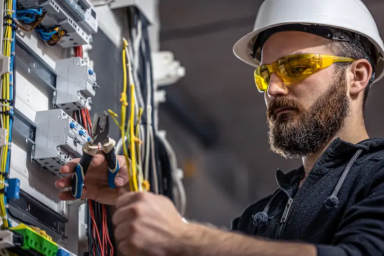 Tecnico che ripara un corto circuito in un impianto elettrico a Bologna