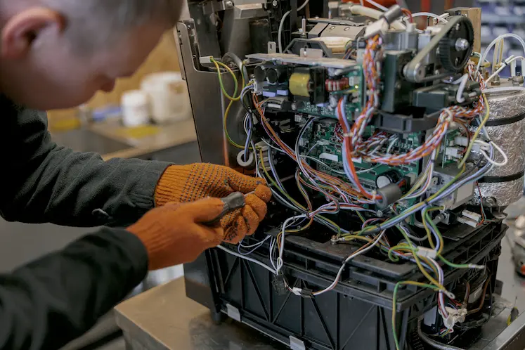 Tecnico che effettua la diagnosi di un guasto elettrico con multimetro